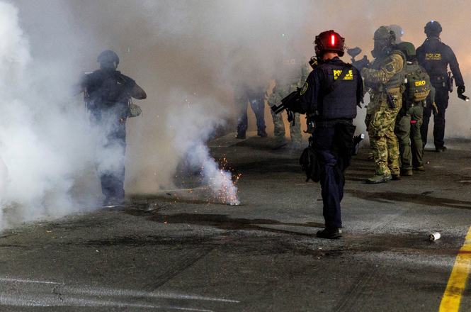 Tear gas and smoke envelop federal agents at anti-deportation protests outside a detention facility in Portland, Oregon, on Sept. 1, 2025. At Aug. 16 protests, videographer Aaron Smith was shot repeatedly with crowd-control munitions while filming.