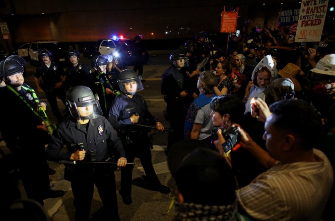 Police officers hold batons and green munition launchers during a “No Kings” protest in Los Angeles, California, on Oct. 18, 2025.