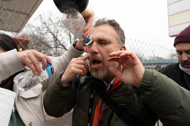Minnesota Public Radio photojournalist Kerem Yücel, center, has his eyes washed out after he was shot with pepper balls and caught in tear gas while reporting on protests of a federal immigration enforcement raid in St. Paul, Minnesota, on Nov. 25, 2025.