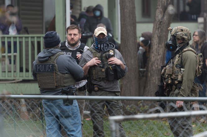 Federal authorities stand guard at a federal immigration enforcement action in St. Paul, Minnesota, on Nov. 25, 2025. Freelance photojournalist Tim Evans was shot with pepper balls while covering protests in opposition to the raid.