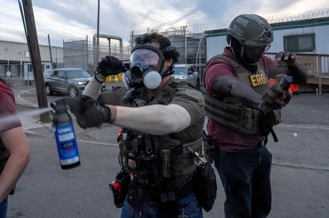 A federal officer, at left, sprays a chemical irritant during an immigration protest outside a detention facility in Newark, New Jersey, on May 26, 2026.