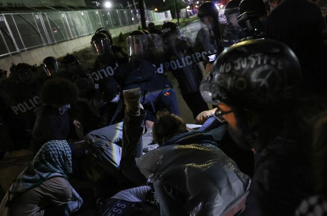 Individuals fall while being pushed by police amid ongoing protests outside a federal detention center in Newark, New Jersey, on June 6, 2026. Status Coup videojournalist Jon Farina was grabbed and shoved by an officer while reporting the following day.