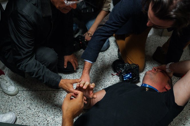 Bystanders assist journalist L. Vural Elibol, chief videographer for Turkey’s Anadolu Agency, as he lies on the floor after being shoved by federal officers while covering detentions in New York City’s immigration court on Sept. 30, 2025.