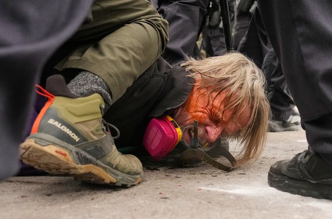 Federal agents push photographer John Abernathy to the ground, pepper spray running down his face, during a confrontation with protesters outside the Bishop Henry Whipple Federal Building in the Minneapolis, Minnesota, area on Jan. 15, 2026.