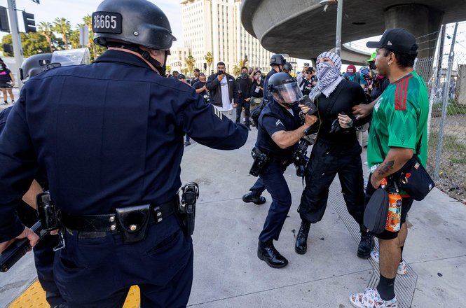 A police officer grabs a protester near an immigration detention center in downtown Los Angeles on March 28, 2026