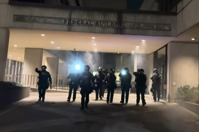 Department of Homeland Security officers advance on journalists and protesters in front of the Federal Building in Eugene, Oregon, on Jan. 27, 2026. A moment later, reporter Agostinho Da Silva was hit by crowd-control munitions fired by officers.