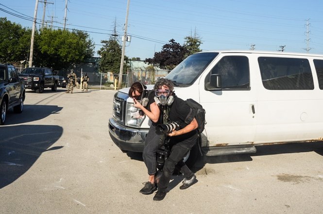 Photojournalist Dave Decker, center right, helps reporter Leigh Kunkel to safety after both were barraged with pepper balls outside a U.S. Immigration and Customs Enforcement facility in the Chicago suburb of Broadview, Illinois, on Sept. 26, 2025.