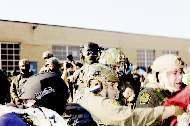 Federal agents, including U.S. Border Patrol Commander-at-Large Gregory Bovino, at right, detain protesters outside a Broadview, Illinois, immigration facility on Oct. 3, 2025. Photojournalist Zach Hussein was shoved while covering the protest.