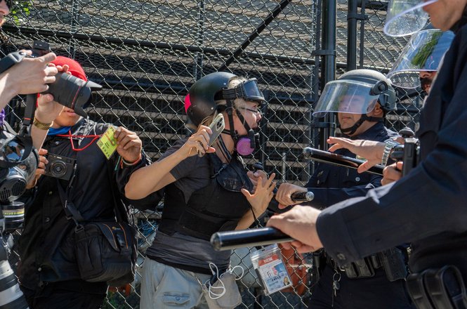 Journalist Tina-Desiree Berg, center, and other members of the press are pushed back by police while covering an immigration protest in Los Angeles, California, on April 11, 2026