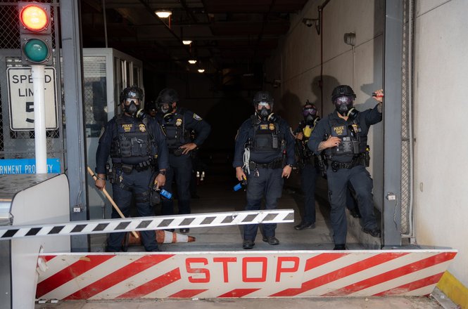 Federal officers gather at an anti-deportation protest in downtown Los Angeles, California, on June 6, 2025. Student photojournalist Jake Crandall was struck with a pepper ball while documenting the demonstration.