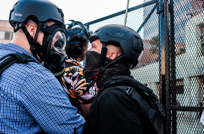 Photojournalist Blake Fagan, at left, is confronted by an individual who later pushed him and attempted to remove his press credential during a protest in Los Angeles on May 1, 2026.