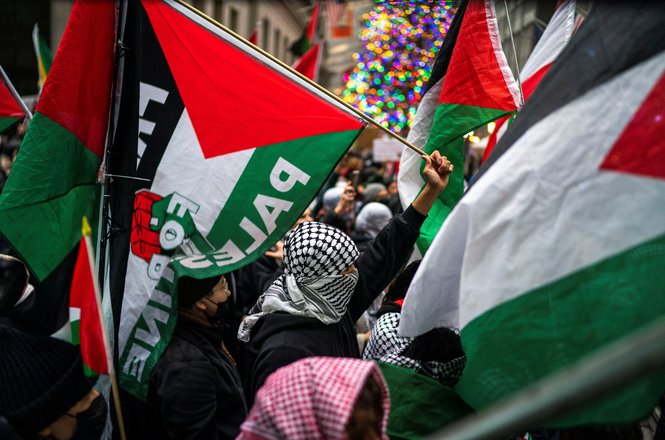 Pro-Palestinian demonstrators march in front of the New York Stock Exchange on Dec. 28, 2023, one in a series of such protests in New York City during the holiday season. Freelance reporter Roni Jacobson was arrested during a similar protest on Dec. 31.