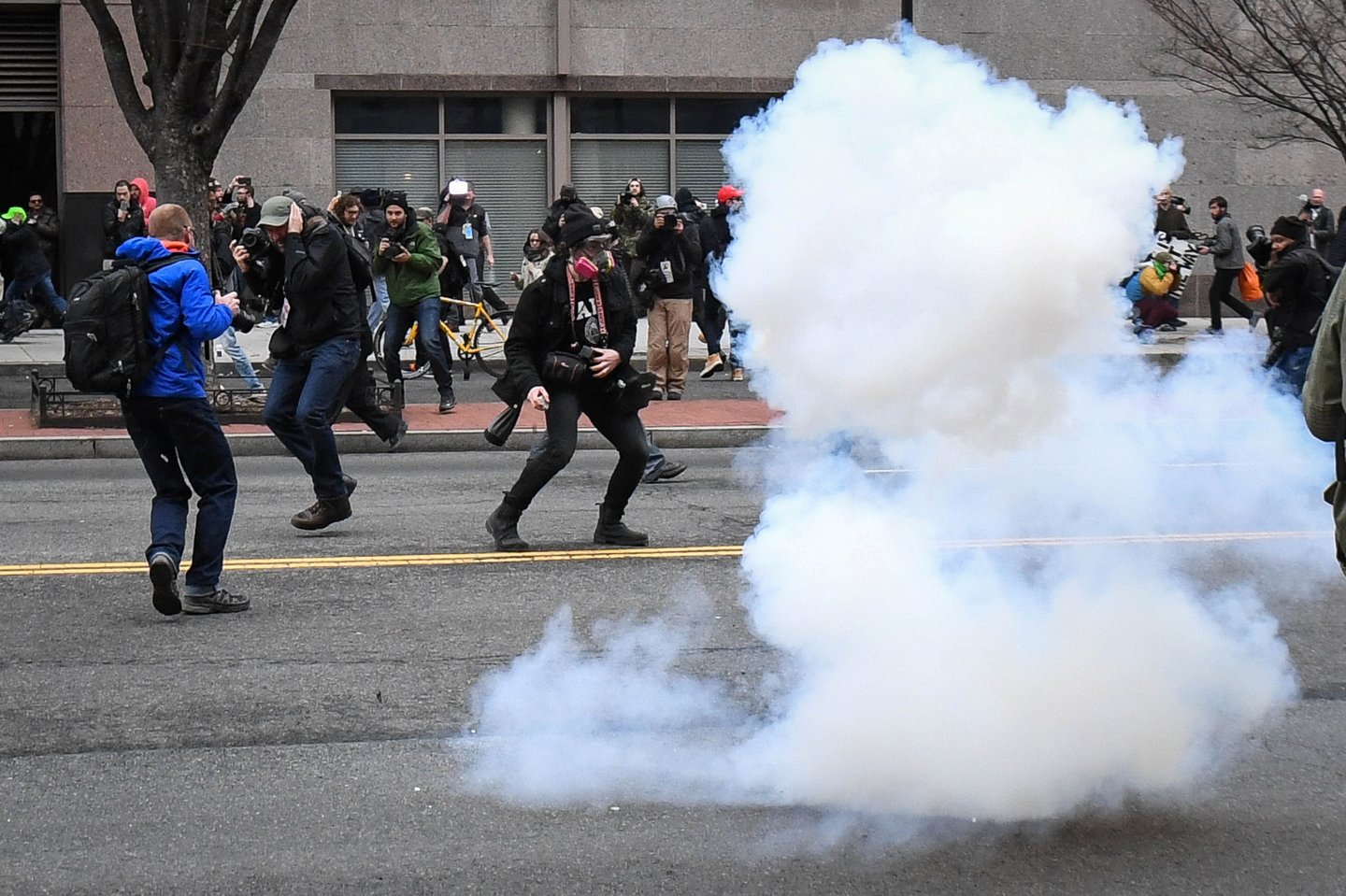 Protesters and journalists scramble as stun grenades are deployed by police during a protest near the inauguration of President Donald Trump in Washington, DC, U.S., January 20, 2017.