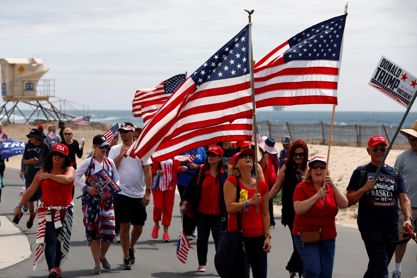 Pro-Trump rally participants carry flags during the Southern California Make America Great Again march in support of President Trump, the military and first responders at Bolsa Chica State Beach in Huntington Beach, California, U.S. March 25, 2017.