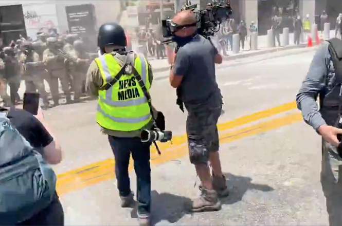 Freelance journalist Sean Beckner-Carmitchel filmed as federal officers shot pepper balls at him and other members of the press documenting protests in downtown Los Angeles on June 8, 2025. A round struck his press credential, damaging it.