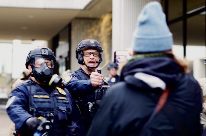 A federal agent fires a chemical irritant at journalists and protesters at the Federal Building in Eugene, Oregon, on Jan. 27, 2026