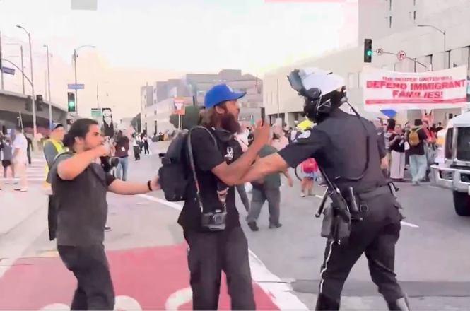 A Los Angeles Police Department officer shoved journalist Lexis-Olivier Ray, at center, during an immigration protest in Los Angeles, California, on Aug. 12, 2025.