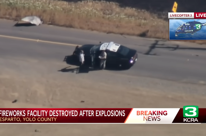 Richard Grant, at left, talks to a California Highway Patrol officer after taking photos at a fireworks warehouse explosion in Esparto, California, on July 2, 2025. He was later arrested for trespassing.