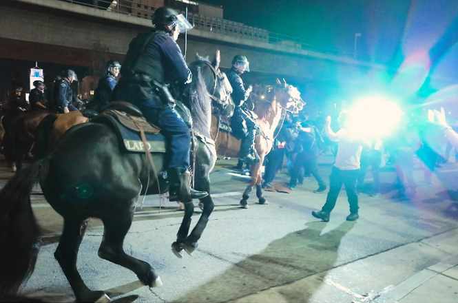 : Mounted police officers push through a group of protesters and media during a “No Kings” protest in Los Angeles, California, on Oct. 18, 2025.