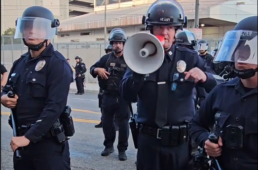 Police kettle protesters and members of the media at a demonstration in Los Angeles, California, on March 28, 2026. Reporter Lexis-Olivier Ray was pushed by an officer and threatened with arrest while covering the demonstration.