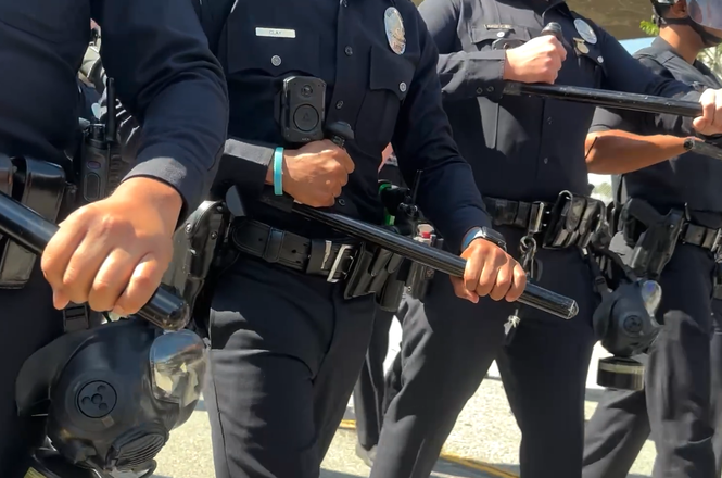 Officers push members of the press back during an immigration protest in Los Angeles, California, on April 11, 2026.