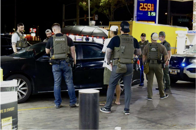 Law enforcement officers conduct an ID check at a gas station in Memphis, Tennessee, on Oct. 4, 2025. Jordyn Gualdani, the photojournalist who captured the image, alleges that the agents later followed his car.