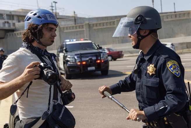 A highway patrol officer with a metal baton challenges a journalist in Los Angeles, California, on June 10, 2025.
