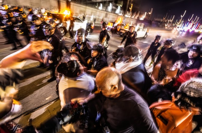Los Angeles Police Department officers push forward during an immigration enforcement protest in downtown LA on Aug. 8, 2025. Documentarian Rocky Romano was hit with a baton and knocked to the ground during a scuffle at the demonstration.
