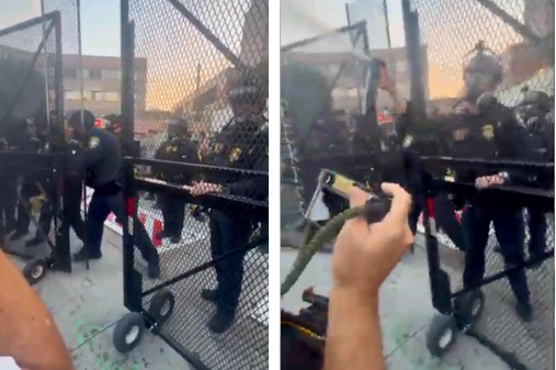 Federal officers stand behind a gate and one pepper-sprays the crowd, at right, during a protest on Sept. 1, 2025.