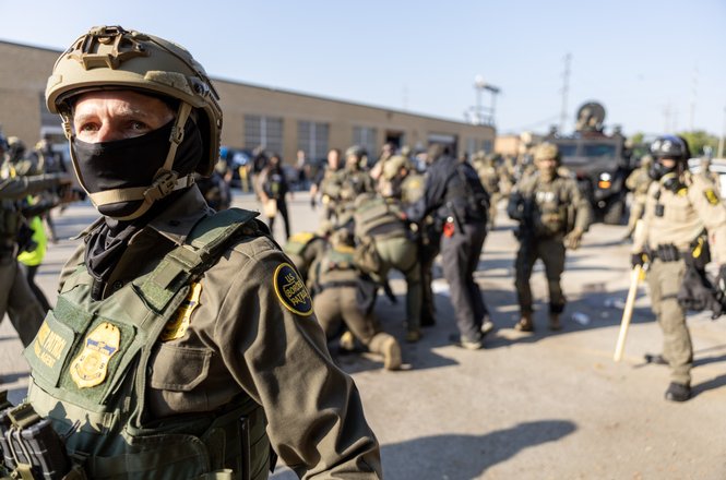 A U.S. Border Patrol officer and other federal agents respond to protests outside an immigration facility in Broadview, Illinois, on Oct. 3, 2025. Officers tackled freelance photojournalist Tom Hudson to the ground while he photographed the demonstration.
