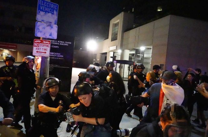 Shutterstock photojournalist Chelsea Lauren, bottom center, being shoved to the ground by Los Angeles police officers, damaging her telephoto lens, while covering anti-deportation protests outside a federal building in downtown LA on Aug. 8, 2025.