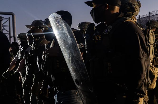 Immigration and Customs Enforcement officers form a line in front of protesters outside an immigration detention facility in Newark, New Jersey, on May 28, 2026. An officer struck a photojournalist’s camera with a baton that day, damaging their flash.