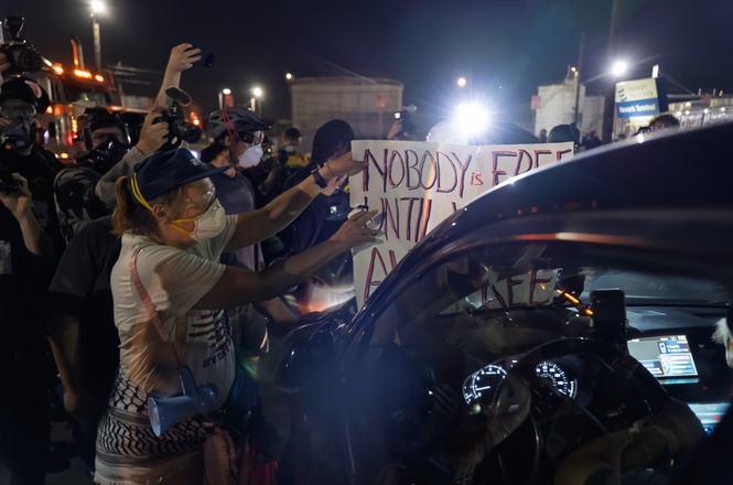 Protesters block a Geo Group employee on June 5, 2026, as they exit from an immigration detention center operated by the company in Newark, New Jersey. Photojournalist Josh Pacheco was struck by an employee’s car as they left the facility that night.