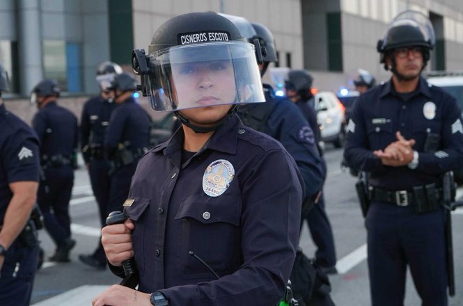 An officer stands in a skirmish line after clearing press and protesters from outside the Metropolitan Detention Center in Los Angeles, California, on May 1, 2026. Journalist Mel Buer was later detained in an LAPD kettle and released without charges.